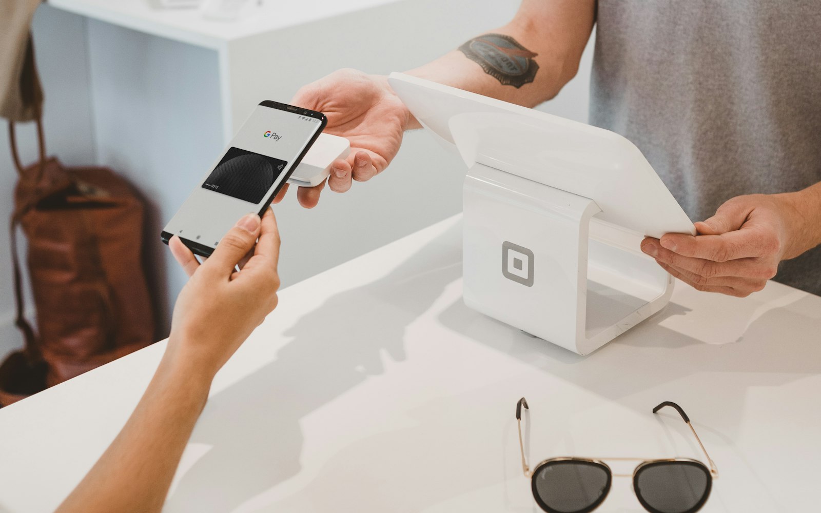 Contactless mobile payment at a store counter, representing custom WooCommerce checkout development